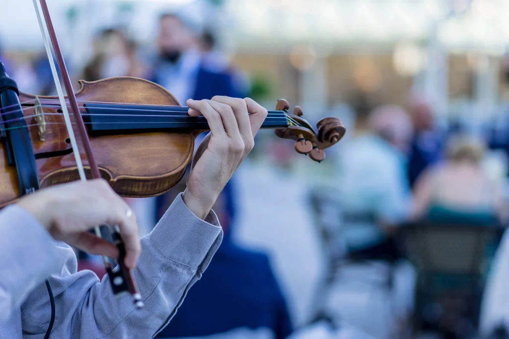 violín siendo tocado por unas manos