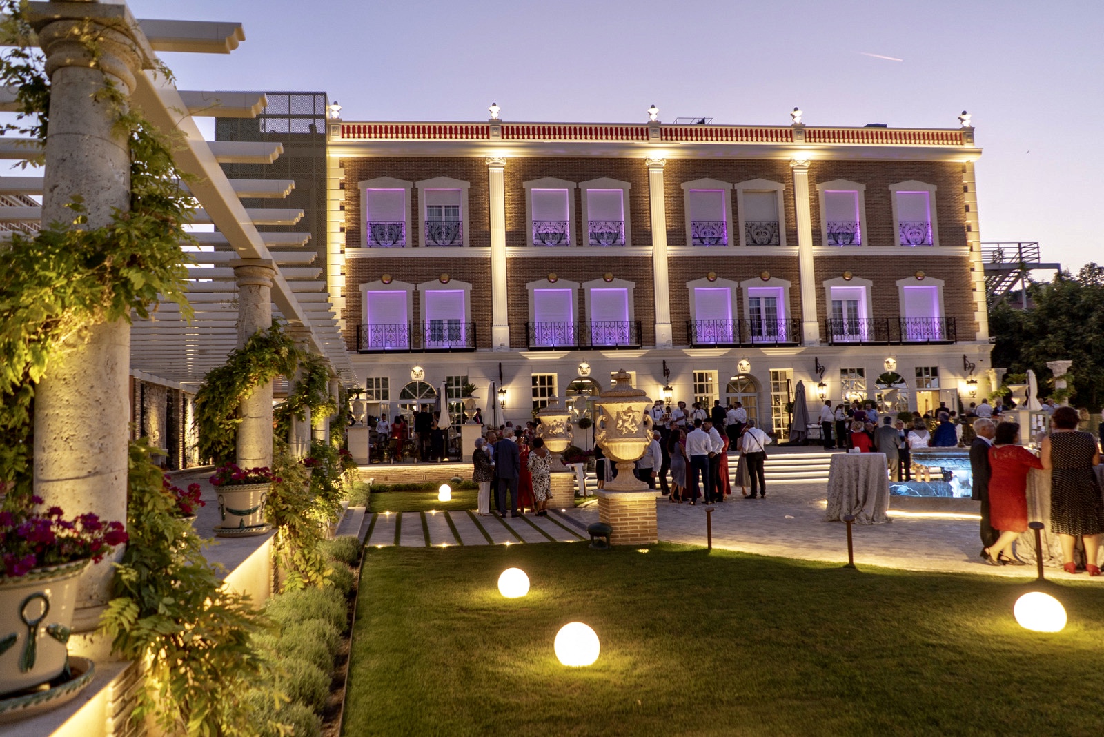 vista de la fachada del palacete de la ochava de noche iluminado con luces desde el jardín