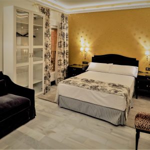 habitación con cama de matrimonio decorada con estilo versace dorado