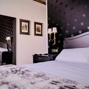 habitación con cama de matrimonio decorada con estilo versace negro